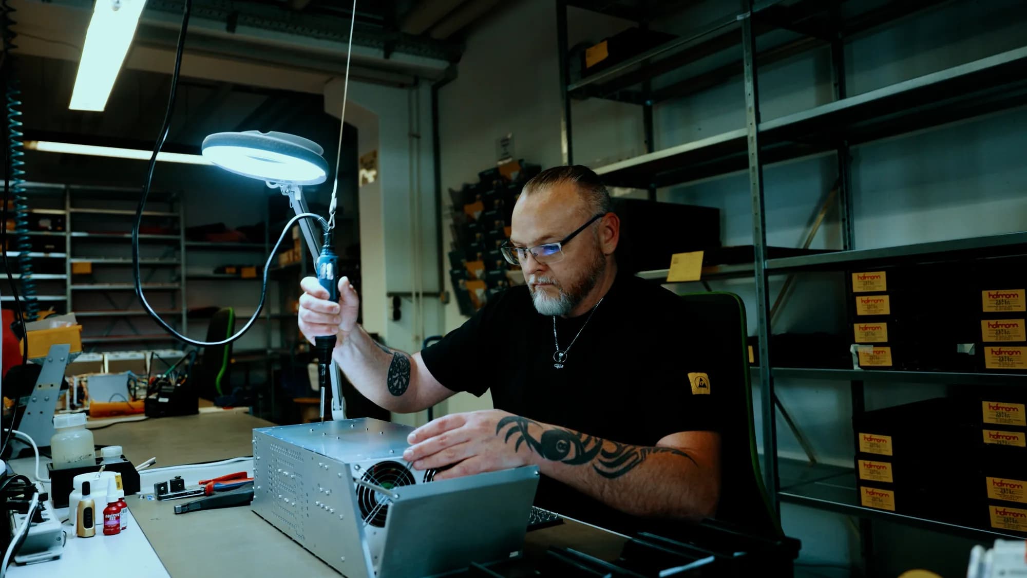 Detailaufnahme einer komplexen Baugruppe aus Metallteilen, Kabeln und Leitungen. Fokus auf die präzise technische Struktur der Elektronikfertigung.