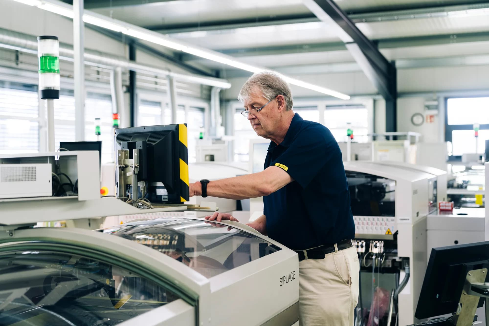 Elektroniker arbeitet an Baugruppe in Produktionsumgebung. Spezialist für SMD Bestückung und Baugruppenfertigung in Nürnberg.